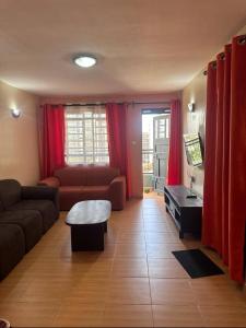 una sala de estar con un sofá y una mesa en The Nest, en Thika