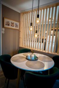 mesa de comedor con 2 velas y sillas verdes en Charming apartment with two bedroms and beautifull sea view in Fauske, en Fauske