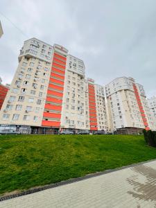 une rangée de grands immeubles d'appartements avec de l'herbe devant dans l'établissement Chișinău MallDova, à Chişinău