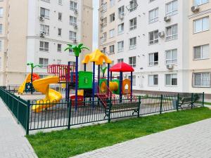 une aire de jeux dans un parc à côté d'un bâtiment dans l'établissement Chișinău MallDova, à Chişinău