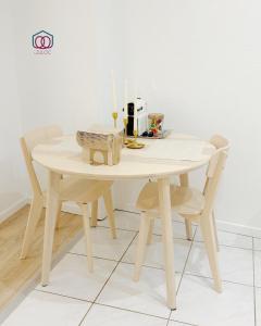einem Holztisch mit 2 Stühlen und einem Tisch mit einer Kerze in der Unterkunft Le Tiny Strasbourg - Adorable logement calme en plein coeur de la ville in Straßburg