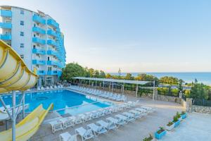 a swimming pool with chairs and a hotel at Club Sun Paradise Hotel in Alanya