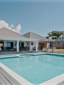 ein Swimmingpool vor einem Haus in der Unterkunft Beachfront villa with pool and staff in Treasure Beach