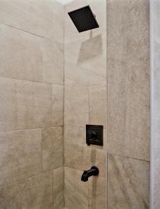 eine Dusche mit schwarzem Duschkopf im Bad in der Unterkunft Beachfront villa with pool and staff in Treasure Beach