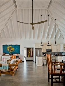 ein Wohnzimmer mit einer Decke und einem Deckenventilator in der Unterkunft Beachfront villa with pool and staff in Treasure Beach