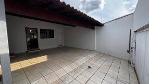 Cette grande chambre dispose d'un mur blanc et de carrelage. dans l'établissement Casa de Temporada - Umuarama 2, à Uberlândia