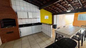 une cuisine avec une table et un mur en briques dans l'établissement Casa de Temporada - Umuarama 2, à Uberlândia 11 autres photos