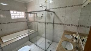 une salle de bain avec douche, lavabo et toilettes dans l'établissement Casa de Temporada - Umuarama 2, à Uberlândia