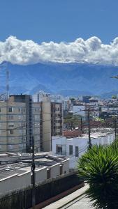 una ciudad con edificios y montañas en el fondo en hotel portal del cerro manizalez, en Manizales
