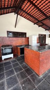 a large kitchen with a brick wall at Família Macapá in Macapá