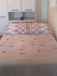 Una cama con un edredón rosa encima. en studio apartman elegant marinkovic, en Vrnjci