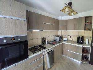 a kitchen with wooden cabinets and a stove top oven at Casa Baraceanu Bran in Bran