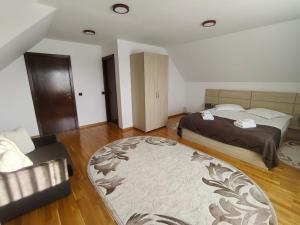 a bedroom with two beds and a rug at Casa Baraceanu Bran in Bran