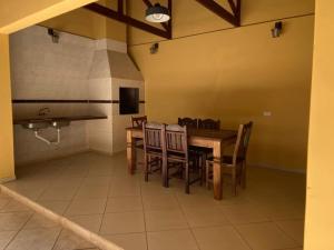 a dining room with a table and chairs at Sobrado Guaratuba 3 quartos in Guaratuba