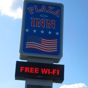 a sign for a pizza inn with an american flag at Plaza Inn Springfield in Springfield