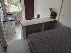 Zimmer mit einem Schreibtisch und einem Bett in einem Zimmer in der Unterkunft Casa Verde Guest in Saco de Fora