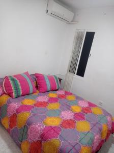 ein Bett mit bunten Kissen in einem Zimmer in der Unterkunft Valencia 2 en piso familiar in Valencia