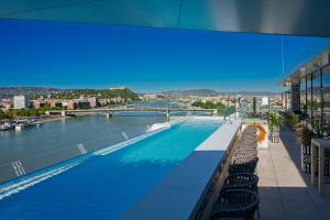 a swimming pool with a view of a river at INFINITY Budapest Hotel - Adults Only in Budapest
