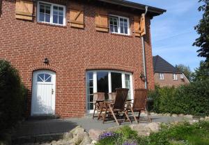 einen Tisch und Stühle vor einem Backsteinhaus in der Unterkunft Hof Rüsch - FeWo Bökenacker in Kesdorf + 9 Fotos