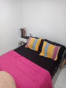 ein Schlafzimmer mit einem Bett mit bunten Laken und Kissen in der Unterkunft Valencia 2 en piso familiar in Valencia