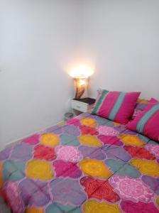 ein Schlafzimmer mit einem Bett mit einer farbenfrohen Tagesdecke in der Unterkunft Valencia 2 en piso familiar in Valencia