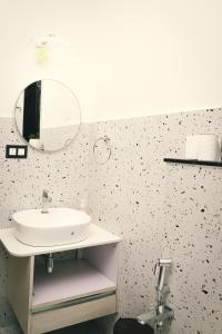 a bathroom with a sink and a mirror at Botanica Luxury 1BHK Apartment, Pool & Parking - Near Candolim Beach in Candolim