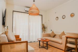 a living room with a couch and a table at Botanica Luxury 1BHK Apartment, Pool & Parking - Near Candolim Beach in Candolim