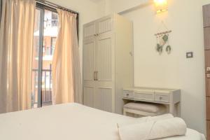 a white bedroom with a bed and a desk at Botanica Luxury 1BHK Apartment, Pool & Parking - Near Candolim Beach in Candolim +5 photos