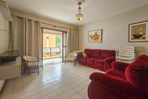 un soggiorno con un divano rosso e un tavolo di Edifício Sunshine Guarujá - Apto Alto Padrão Próximo à Praia a Guarujá