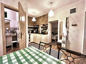 eine Küche und ein Esszimmer mit einem Tisch im Zimmer in der Unterkunft Ladislaus Schnaps-Haus Falusi Vendégház in Csolnok