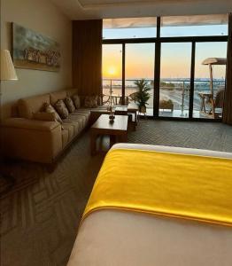 a living room with a yellow bed and a couch at Golden Studios in Jeddah