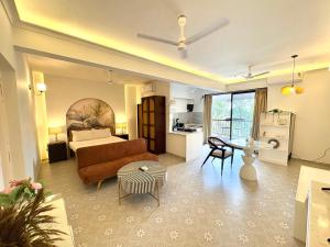 Una sala de estar con un sofá, una cama y una mesa. en Modern Studio with Pool Access Near Candolim Beach - Balcony & Kitchenette, en Candolim 27 fotos más