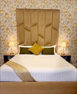 a bedroom with a large bed with a large headboard at Golden Studios in Jeddah