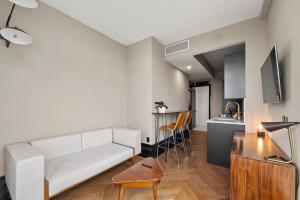 Una sala de estar con un sofá blanco y una cocina. en Freeman 903 by Rove 1BR Condo with Shared Amenities, en Nueva York