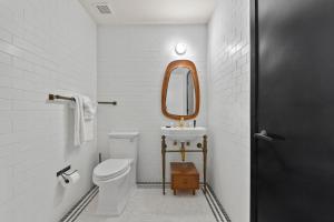 Un baño con inodoro, lavabo y espejo. en Freeman 903 by Rove 1BR Condo with Shared Amenities, en Nueva York 21 fotos más