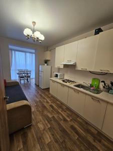 a kitchen with white cabinets and a dining room at Яровиця 61 in Lutsk