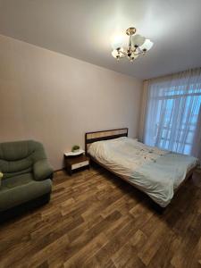 a bedroom with a bed and a couch and a chair at Яровиця 61 in Lutsk