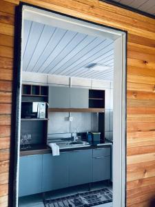 eine Küche mit Spüle und Mikrowelle in der Unterkunft Casa do Aconchego in São Joaquim