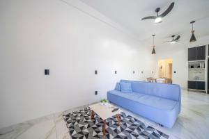 a living room with a blue couch and a table at Casa em Bombinhas in Bombinhas
