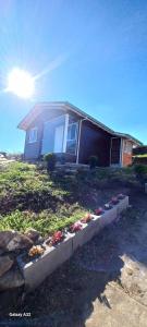 ein Haus mit einem Blumenbeet davor in der Unterkunft Casa do Aconchego in São Joaquim