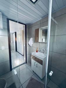 ein Badezimmer mit Waschbecken und Dusche in der Unterkunft Casa do Aconchego in São Joaquim