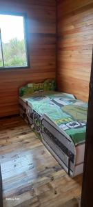 ein Schlafzimmer mit einem Bett in einem Holzzimmer in der Unterkunft Casa do Aconchego in São Joaquim + 21 Fotos