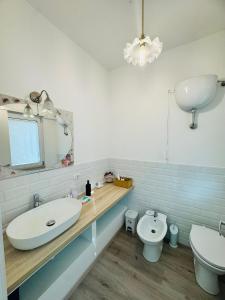een badkamer met een wastafel, een toilet en een spiegel bij Casa Vacanze Anice e Cannella in Palestrina