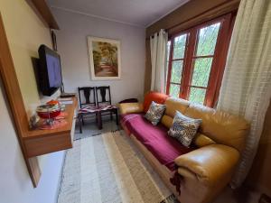 ein Wohnzimmer mit Sofa und Fernseher in der Unterkunft Refugio na Natureza in Santo Antônio do Pinhal