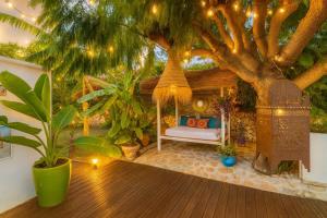 ein Pavillon mit einer Couch unter einem Baum in der Unterkunft Hotel Altea Paradise 1917 - Adults Only in Altea