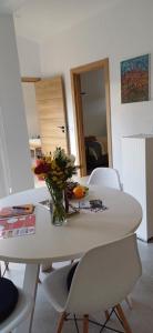 ein weißer Tisch mit einer Vase Blumen drauf in der Unterkunft Quinta da pêra rocha in Alcobaça