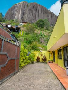 un bâtiment avec une montagne en arrière-plan dans l'établissement Hermosa casa de campo en GUATAPÉ, à Guatapé