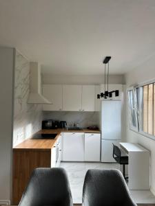 a kitchen with white cabinets and a table and chairs at Aurora Apartament in Inari