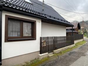 une maison blanche avec une clôture et une fenêtre dans l'établissement Chata Mária, à Liptovská Lúžna