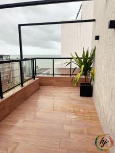a balcony with a potted plant on top of a building at Mares 502 in Tambaú